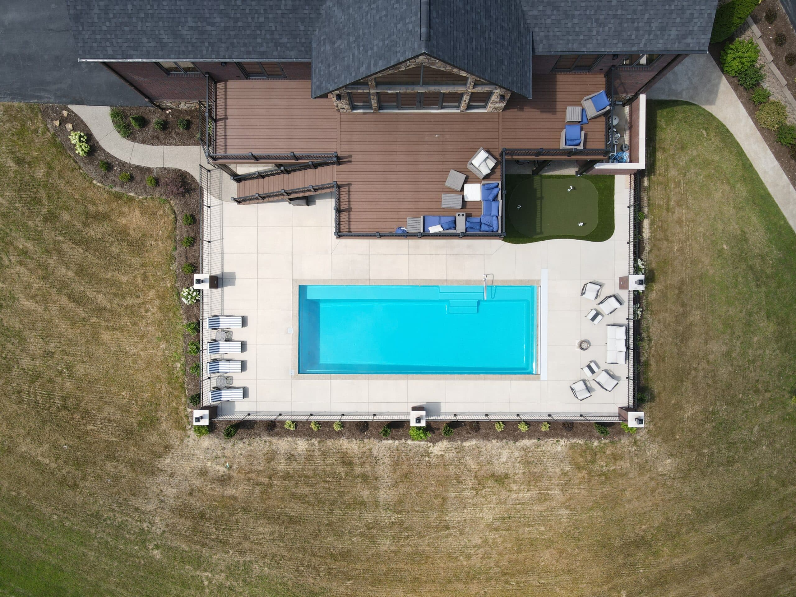 Image of a fiberglass pool installation in a residential backyard, seen from above